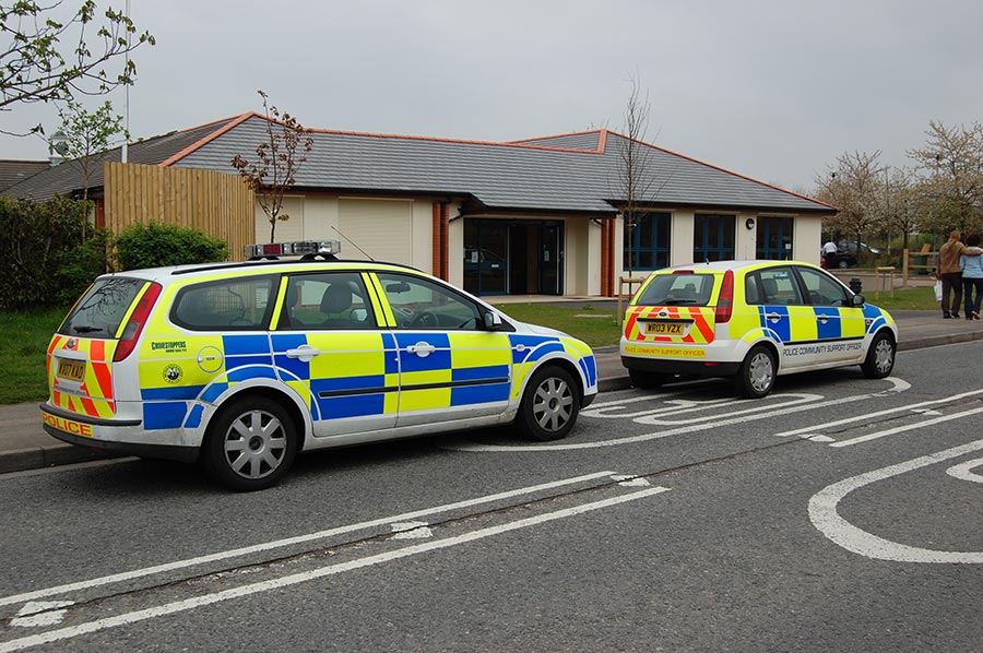 Police cars parked outside Baileys Court Activity Centre, Bradley Stoke. Photo of two police cars parked on a road in front of a community building.