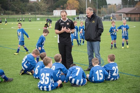 Sir Geoff Hurst watches Bradley Stoke Youth FC coach Jim Murdoch working with the U8 squad.