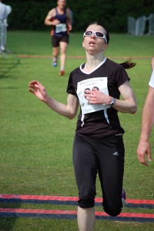 Antonia Burt crosses the line in the Bradley Stoke 10k Run 2015.