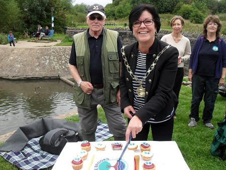 Cllr Erica Williams cuts the Three Brooks Nature Conservation Group's tenth birthday cake.