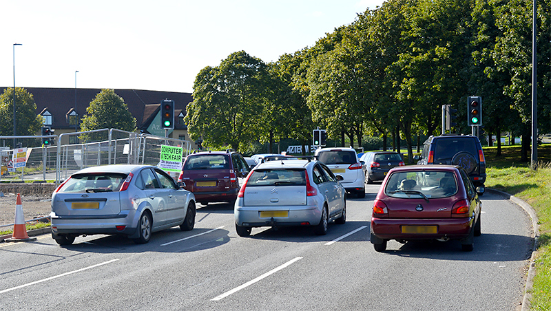 The westbound carriageway of Bradley Stoke Way at its junction with the Aztec West Roundabout.