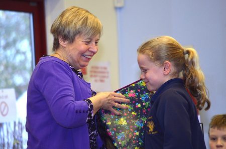 Christine Dursley, headteacher of Wheatfield Primary School, receives a gift from a pupil at a special assembly to mark her retirement after 18 years in the post.