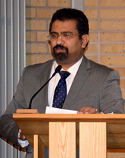 Cllr Tom Aditya addresses a public meeting called to discuss a surge in burglaries in Bradley Stoke.