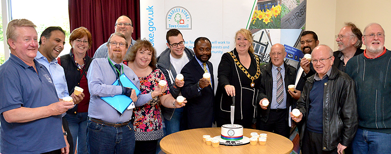 Photo of mayor Elaine Hardwick cutting a cake to mark the 25th anniversary of Bradley Stoke Town Council, watched by other members of the council.