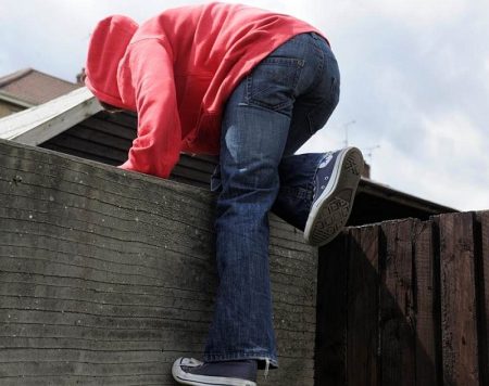 Library image of someone climbing over a wall. 