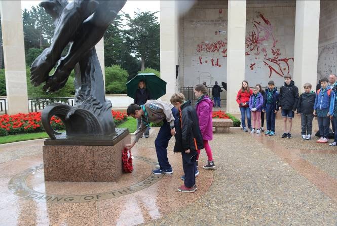 Members of the 1st Bradley Stoke Scout Group lay a wreath at the Normandy American Cemetery.