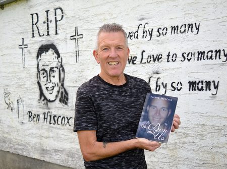 Photo of Clive Hiscox at the Trust Ground with a copy of the book he has written.