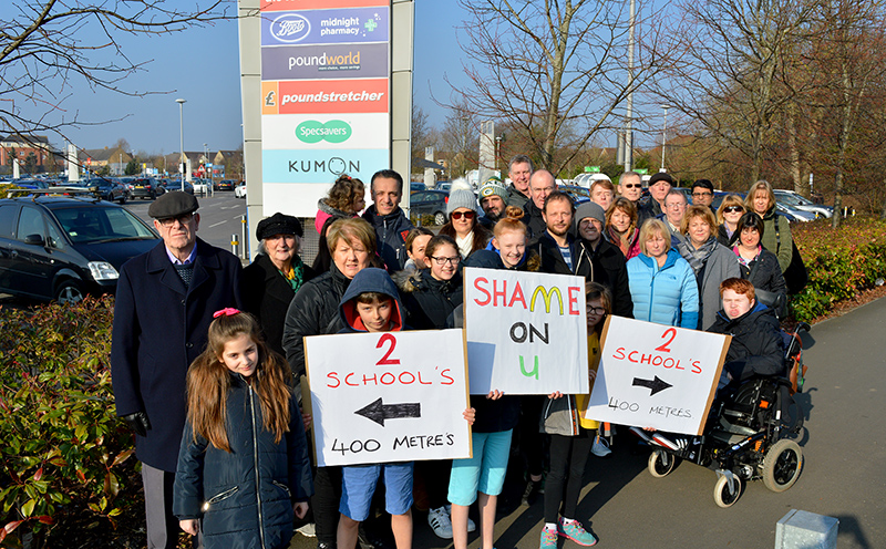 Photo of around 30 protesters, some holding placards, outside the Willow Brook Centre.