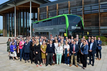 Photo of a crowd of dignitaries standing in front of a MetroBus vehicle at the M3 Route launch event.