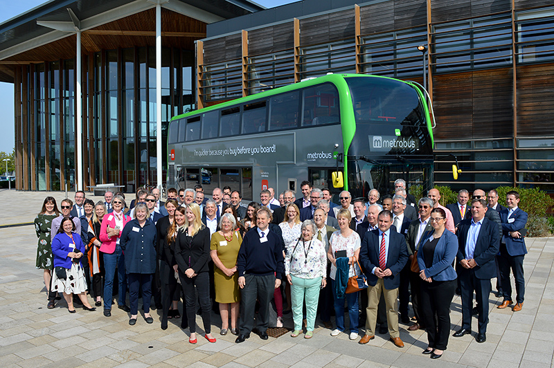 Photo of a crowd of dignitaries standing in front of a MetroBus vehicle at the M3 Route launch event.