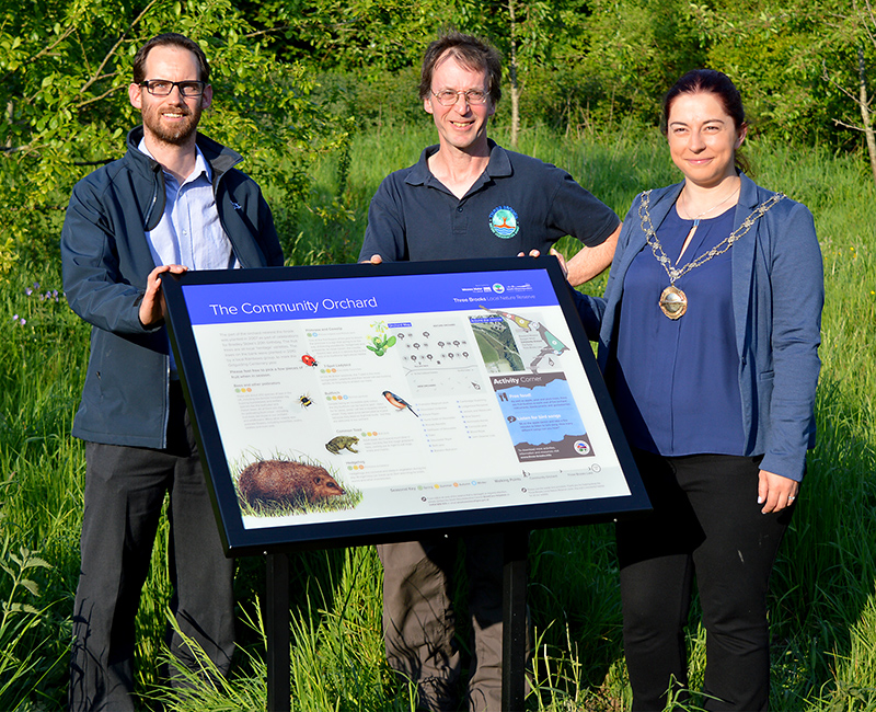 Photo of the panel unveiling in the community orchard. L-r: Jamie Bowkett (senior ecologist, Wessex Water), Robin Jones (chair, Three Brooks Nature Conservation Group) and Cllr Rachel Hunt (chair, South Gloucestershire Council).