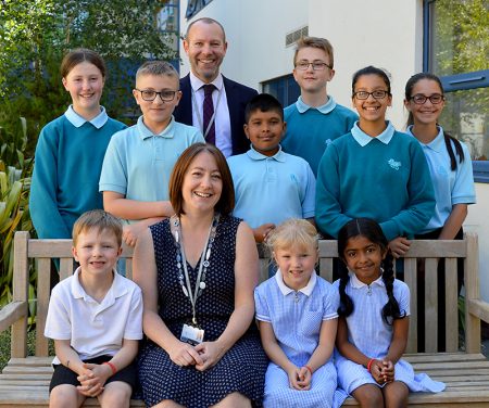 Photo of BSCS staff and students. Standing is Steve Moir (headteacher); seated is Sharon Clark (head of primary phase).