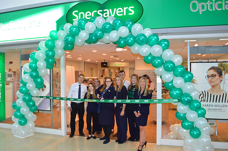 Photo of staff standing under a balloon arch at the entrance to the store.