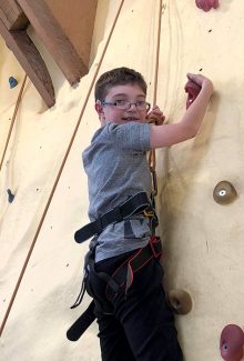 Photo of Calum Morris on a climbing wall.