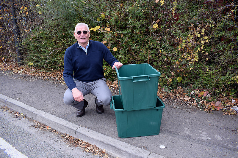 Photo of Cllr Paul Hughes with green recycling boxes.