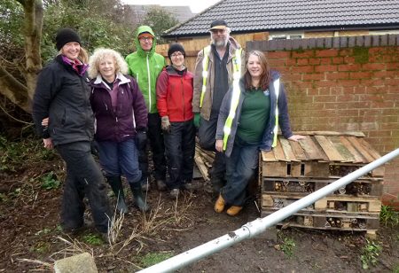 Photo of Bradley Stoke in Bloom volunteers with an insect hotel at Manor Farm Corner.