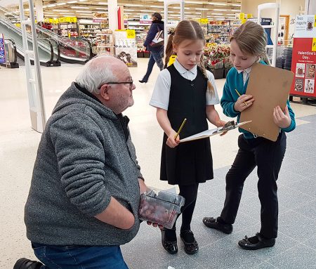 Photo of pupils interviewing a shopper as part of their survey work.