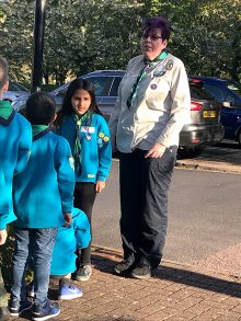Photo of Donna Carl standing in front of a group of Beaver Scouts.