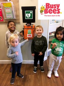 Photo of children pointing out the setting's newly installed defibrillator.
