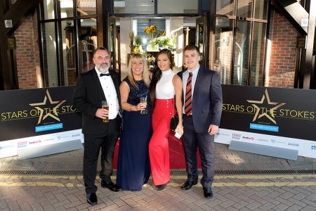 Photo of a group of guests posing for photos on the red carpet.