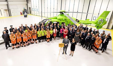 Photo of a large group of attendees standing in front of the air ambulance.
