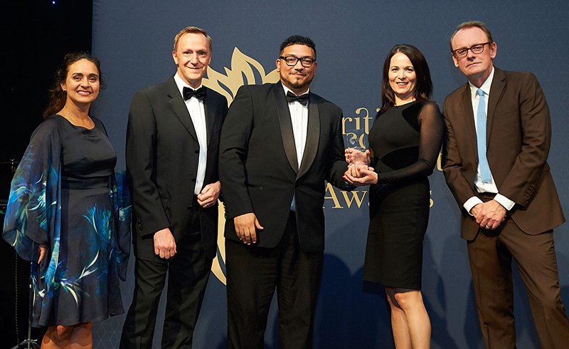Photo of Natasha Miller (left), Matthew Dobbins (2nd from left) and Lisa White (2nd from right) receiving the award, in the presence of TV comedian Sean Lock (right).