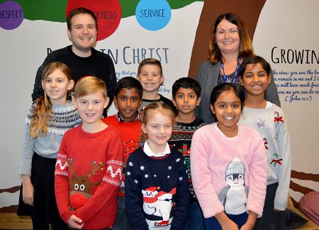 Photo of teachers and pupils at Holy Trinity Primary School celebrating their recent 'good' grading by Ofsted.
