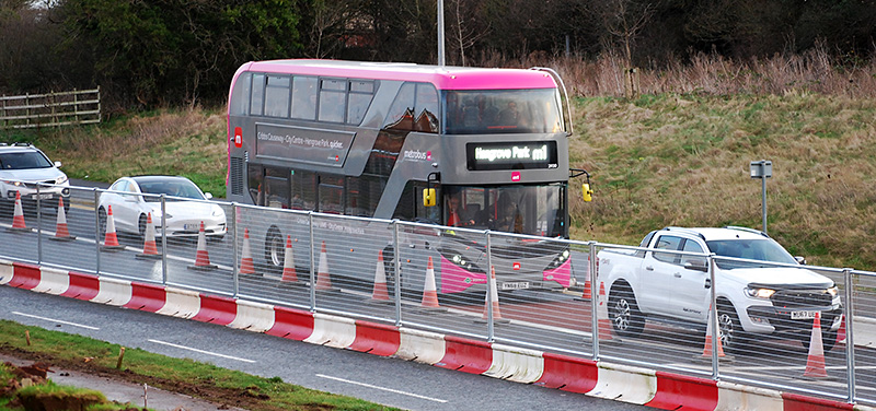 Photo of an M1 MetroBus vehicle stuck in a queue of traffic on the approach to Great Stoke Roundabout.