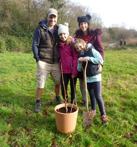 Photo of the Edgely family planting their sapling.