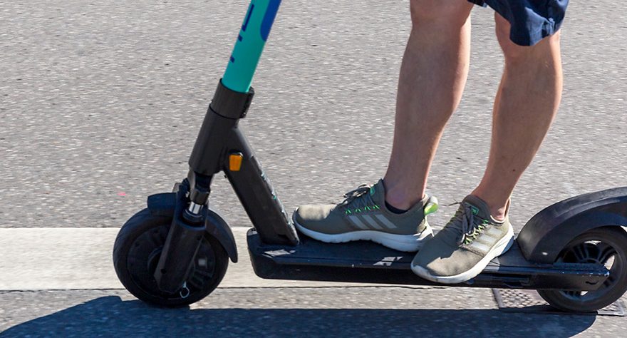 Photo of a man riding an e-scooter.