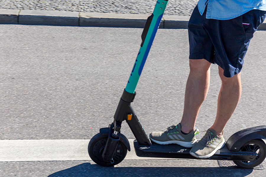 Photo of a man riding an e-scooter.