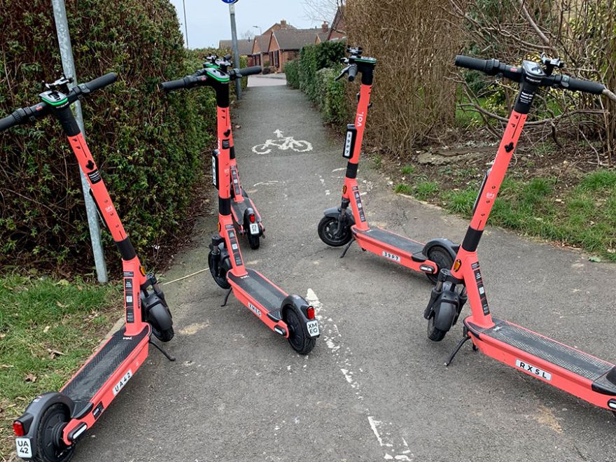 Photo of Voi e-scooters blocking a path.