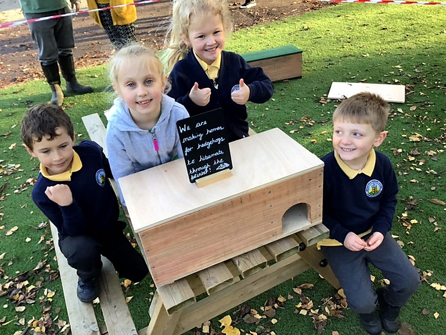 A hogbox (hedgehog box) made by some of the Wheatfield pupils. Photo of a group of pupils with a hogbox.