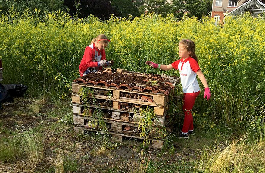 Photo of two children with a stack of pallets.