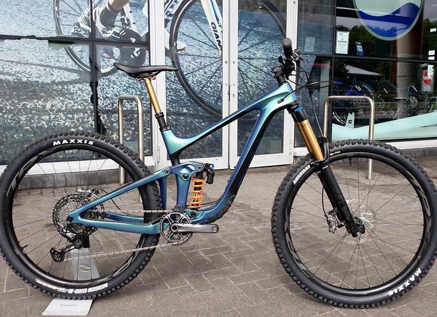Photo of a mountain bike standing in front of a shop front.