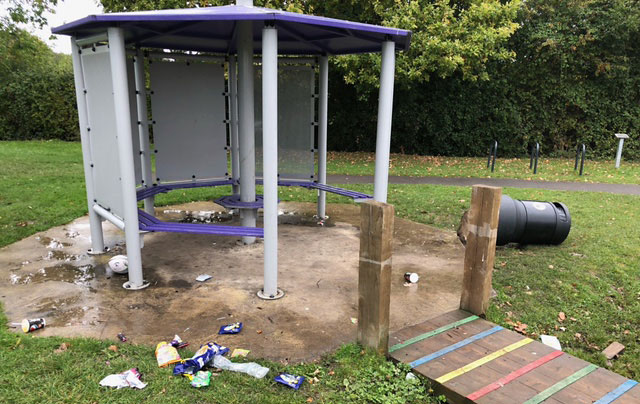 Photo of a vandalised shelter and upended litter bin.