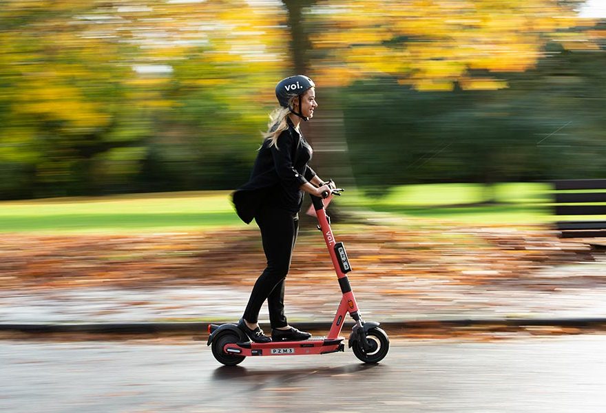 Photo of a person riding an e-scooter.