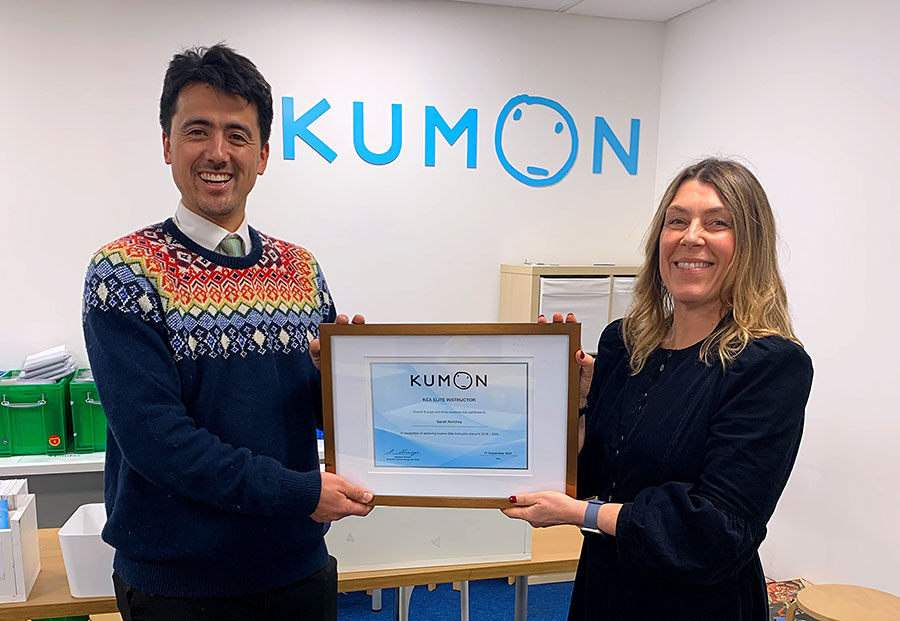 Sarah Nutchey receives her Elite Instructor award certificate. Photo of an award certificate presentation.