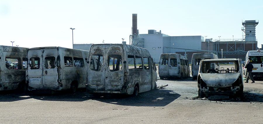 Aftermath: Burnt-out minibuses in a car park within the Rolls-Royce site, Patchway. Photo showing a number of burnt-out minibuses.