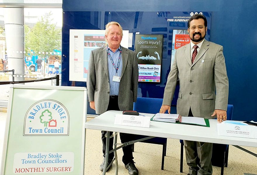 Photo of two men standing behind a table.