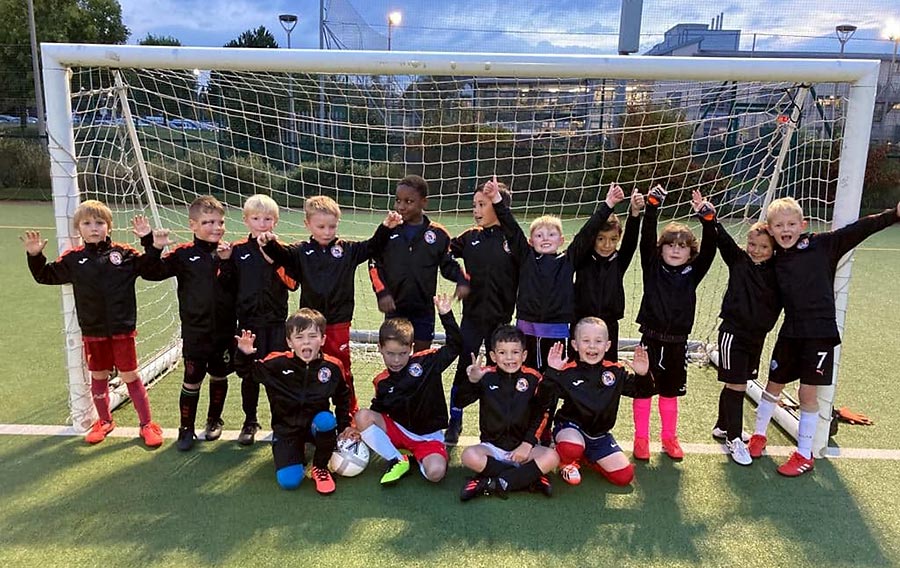 Bradley Stoke Youth FC Under-7 players in their new matchday jackets kindly donated by the Luke Wheaton Legacy Trust. Photo of a youth football team standing in a goal mouth.