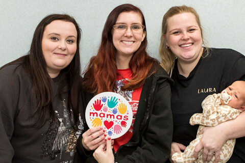 Photo of three women, one holding a baby.