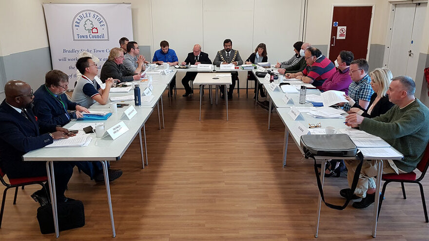 Photo of councillors seated around tables at a meeting.