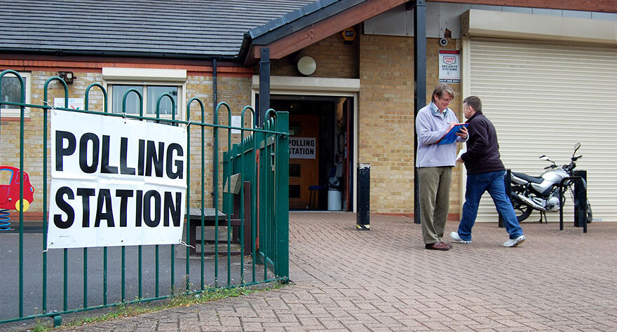 Photo of a teller outside a polling station.