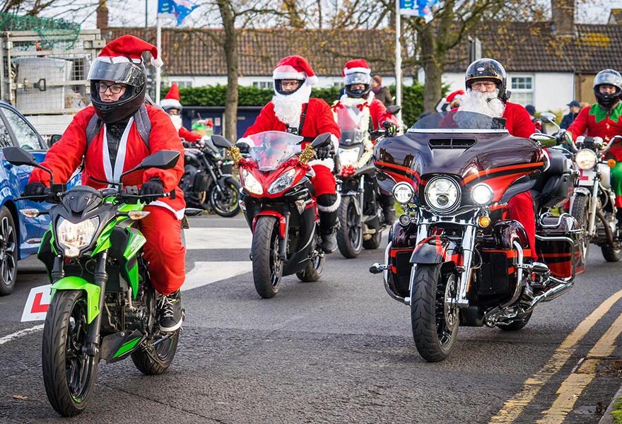 Photo of a column of motorcycles with riders dressed in Santa outfits.