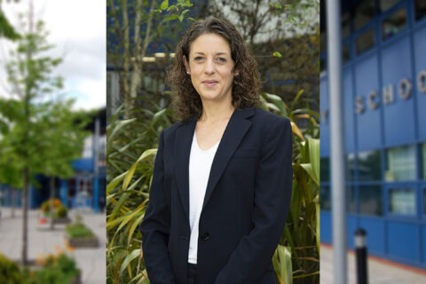 Composite image showing a female headteacher with a blurred background of a school building and grounds.