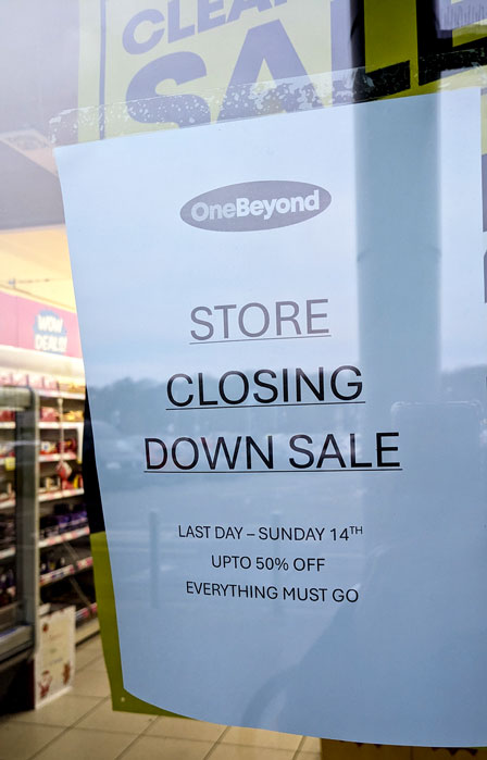 Photo of a notice in a shop window displaying the title 'Store Closing Down Sale'.