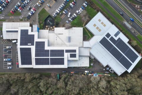 Aerial photo of a leisure centre that has solar panels on its roof.
