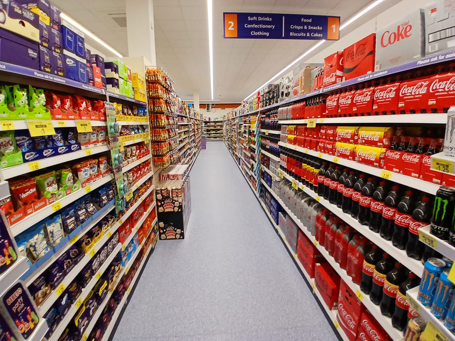 Soft drinks and confectionary aisle within the new B&M store in Bradley Stoke, Bristol. Photo of an aisle within a supermarket.